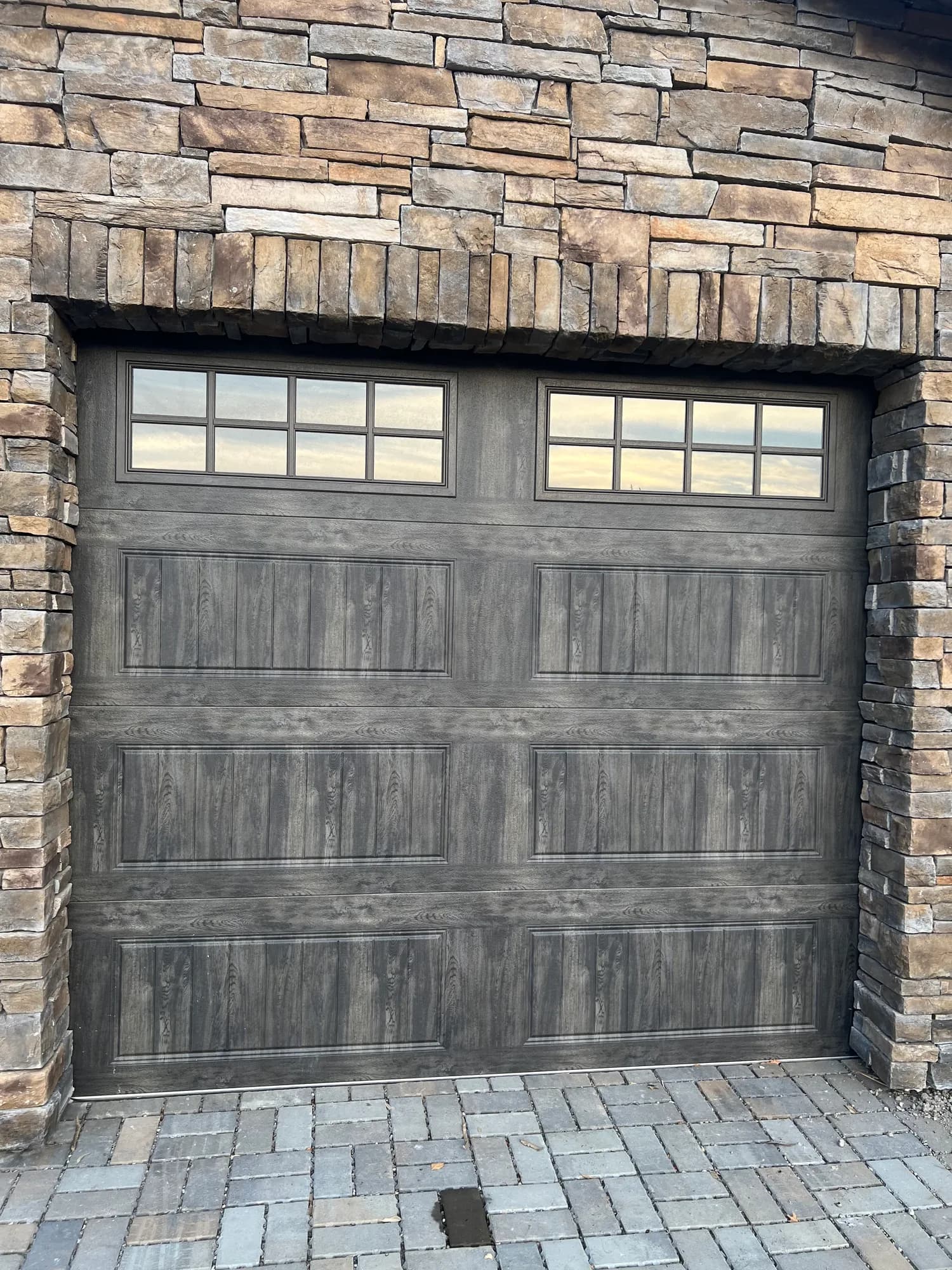 Dark wood garage door on a stone home