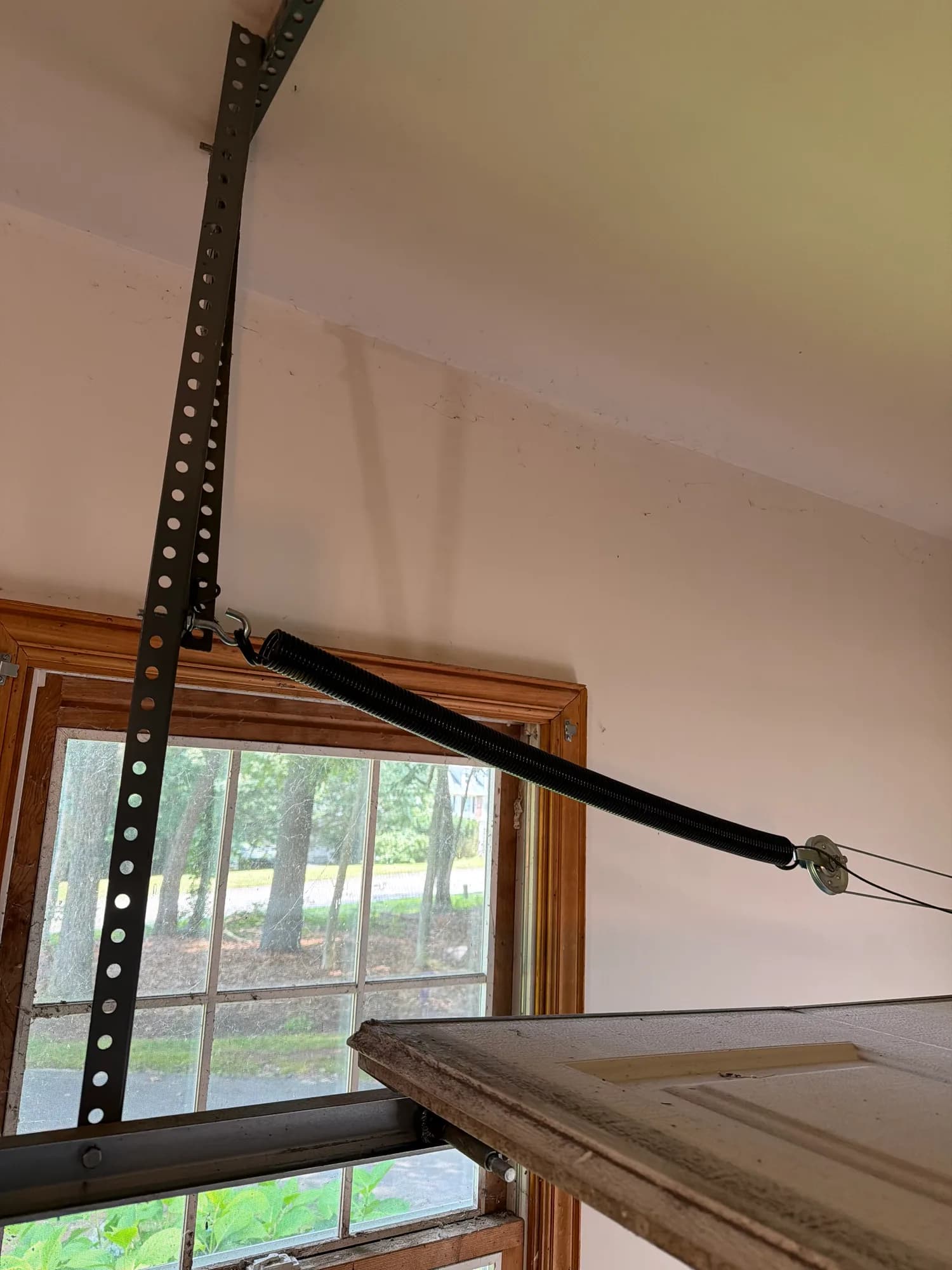 Garage door torsion spring and lift cable together on the header