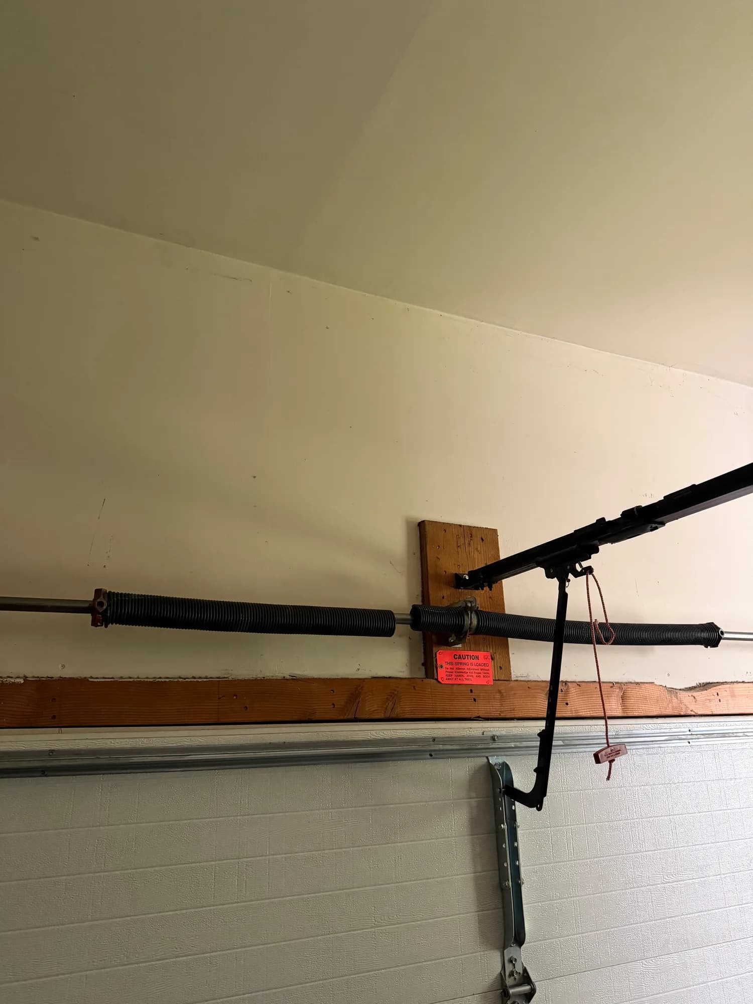 Close-up of a garage door torsion spring on the header shaft