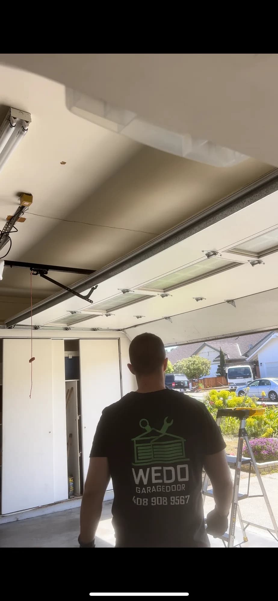 Technician at an open garage door on a job site