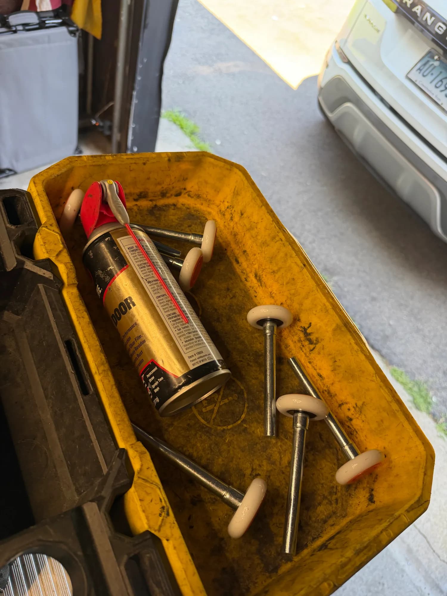 Garage door rollers and lubricant during a hardware service