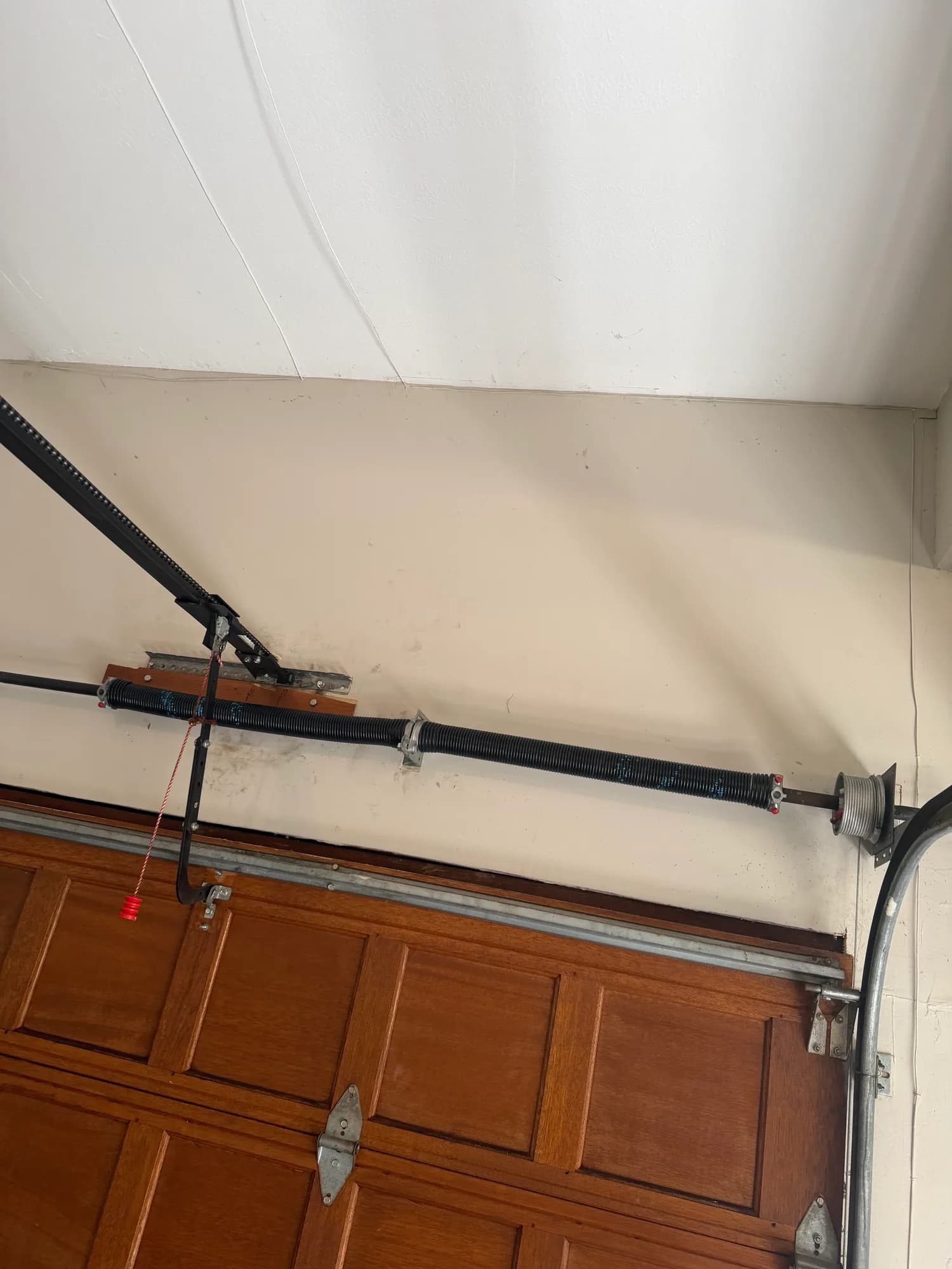 Garage door torsion spring above a residential opening
